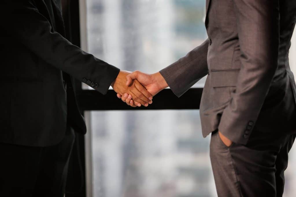 Two professionals shaking hands in an office